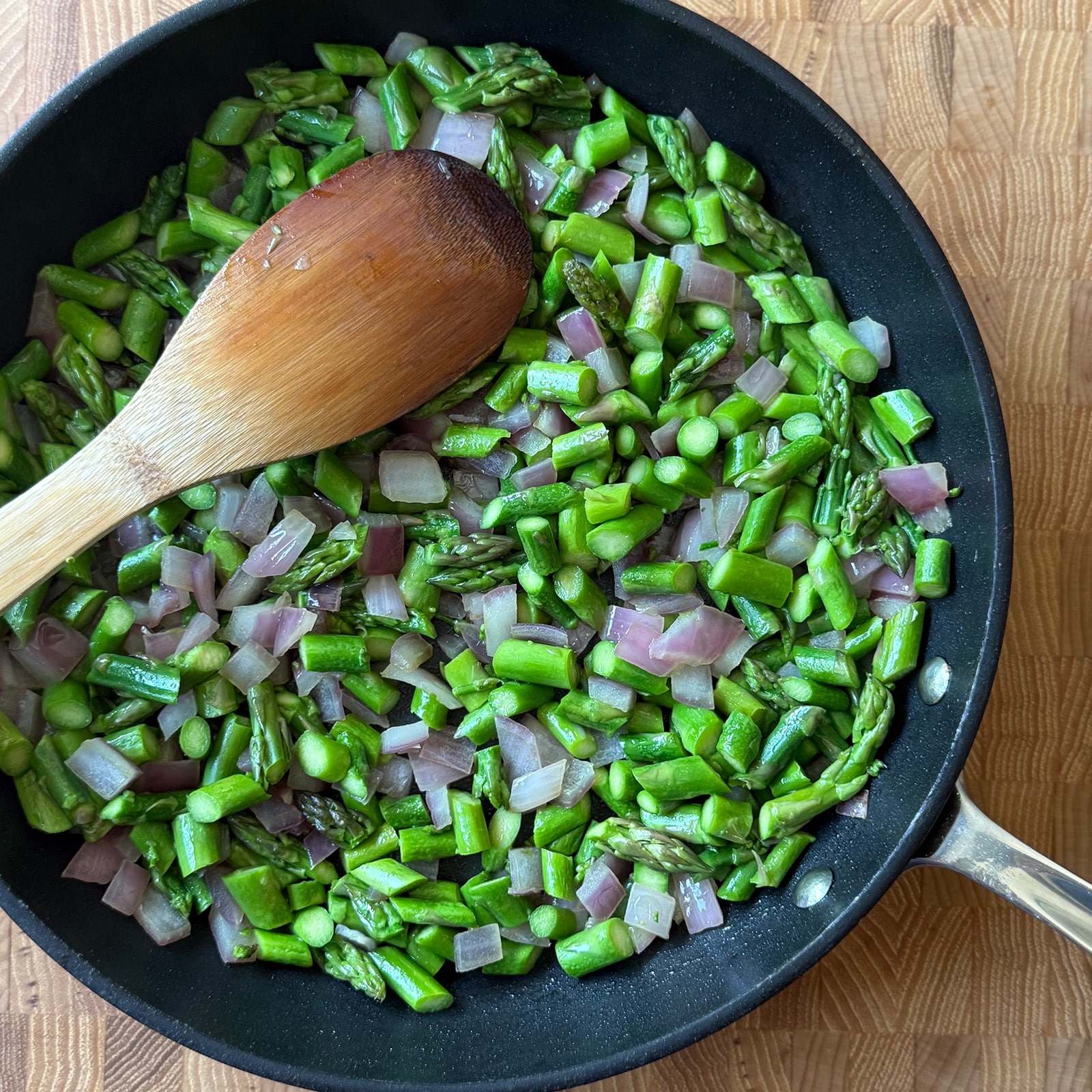 asparagus and red onion in a skillet