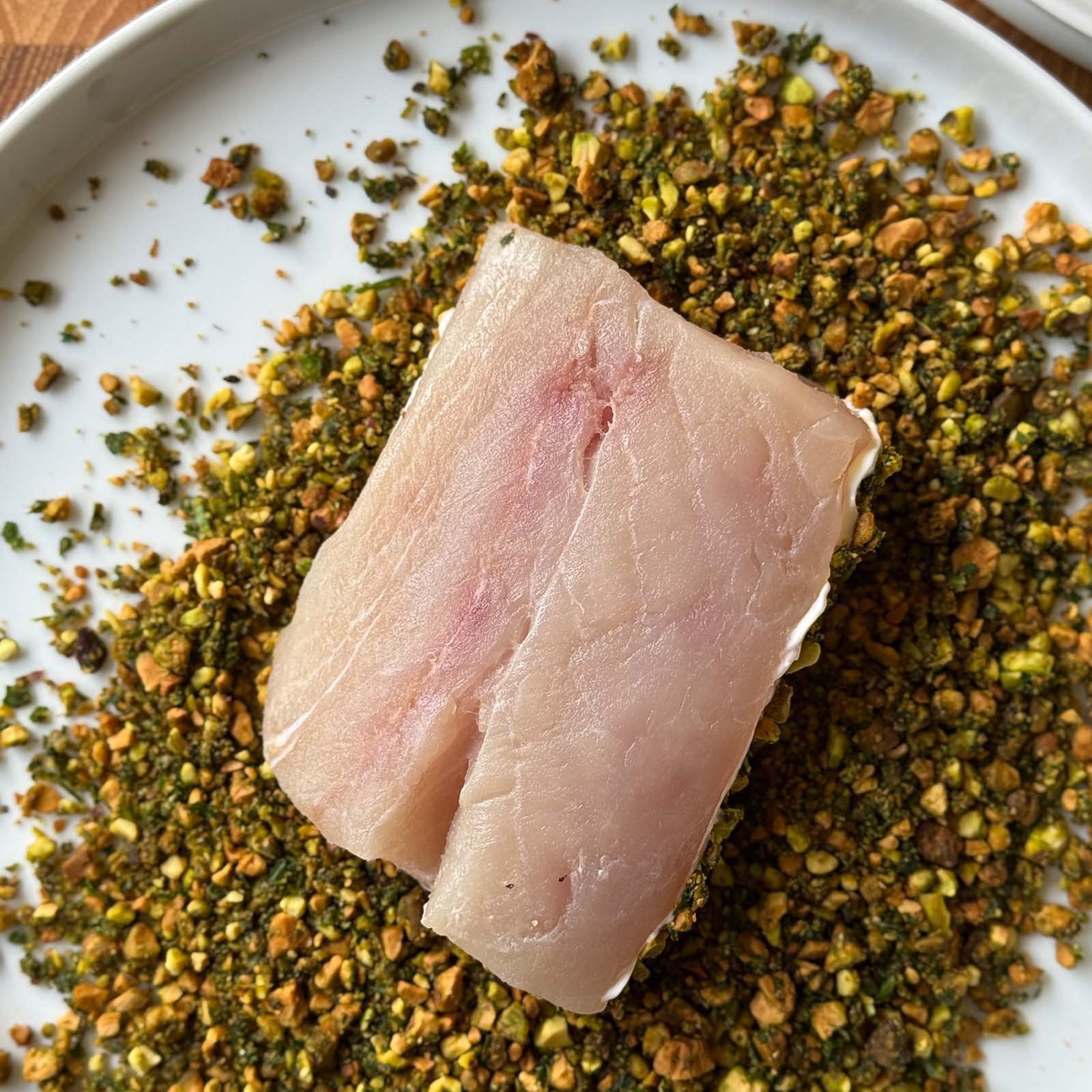 Fish pressed into pistachio crust mixture