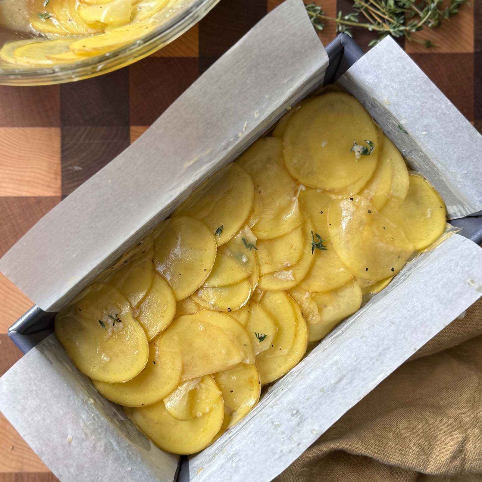 Potatoes Layered in a Parchment Lined Pan with Butter Broth