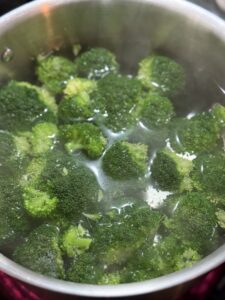 Blanched Broccoli floating in a pot of water