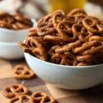 A bowl of Seasoned Barbecue Ranch Pretzels with a few spilled onto the counter