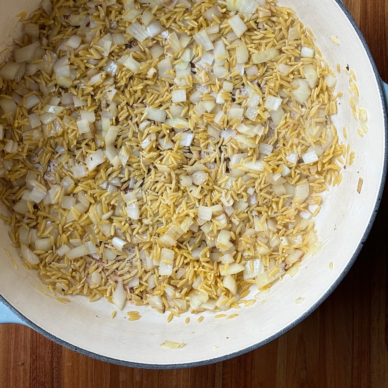 toasted orzo in a pot with onion